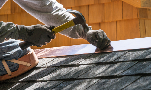 Hammering nail into roof tin